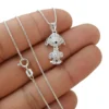 Collar de Snoopy en plata ley 925 con pavé de brillantes CZ sobre una mano. Muestra el diseño detallado del dije de Snoopy y el brillo de los circones con su cadena italiana.
