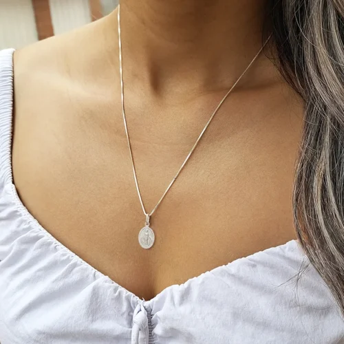 Mujer usando collar con dije de la Virgen Milagrosa en plata 925 italiana