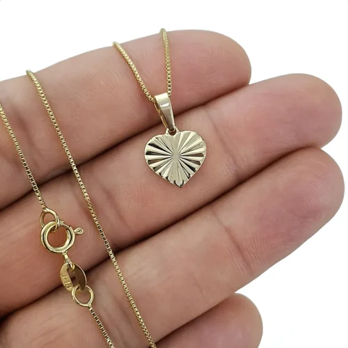 Primer plano de cadena con dije de corazón diamantado en oro laminado 18k para mujer