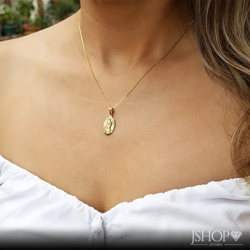 Mujer luciendo la medalla de la virgen guadalupe con cadena oro laminado 18k.