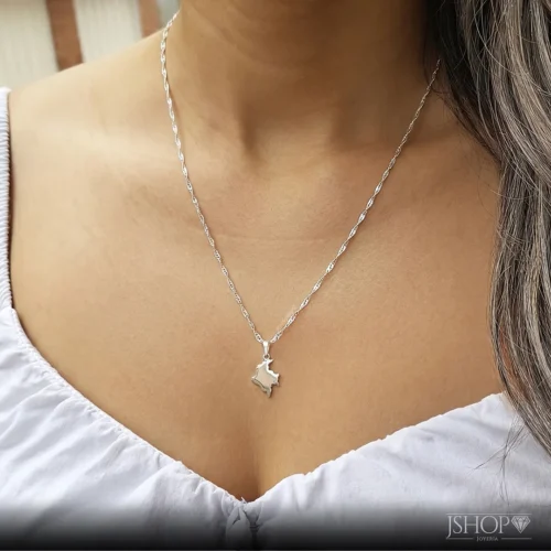 Mujer luciendo el dije mapa Colombiano en plata 925 con cadena y diseño elegante inspirado en Colombia