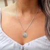 mujer luciendo la medalla de San Benito de Plata 925 italiana auténtica con un diámetro de 2cm y caida de 50cm de largo.
