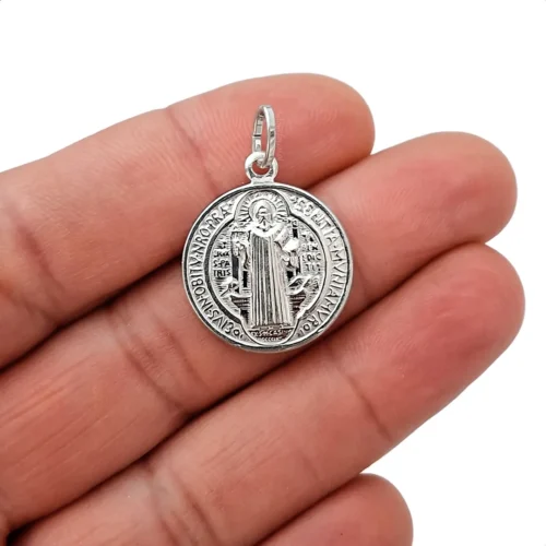Primer plano del dije medalla de San Benito en plata 925 italiana mostrando detalles y acabado brillante y em alto relieve.